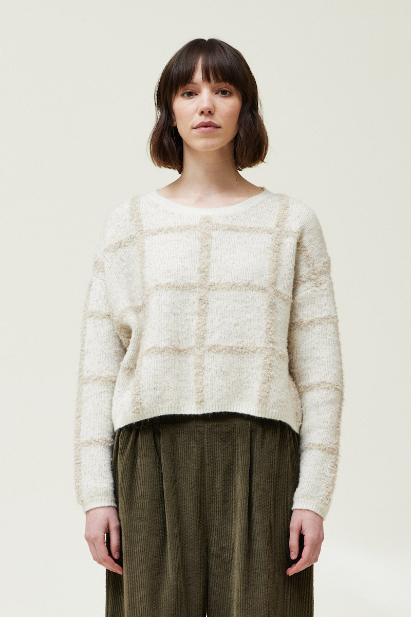 Front view of a woman wearing an Ivory Cropped Grid Sweater 