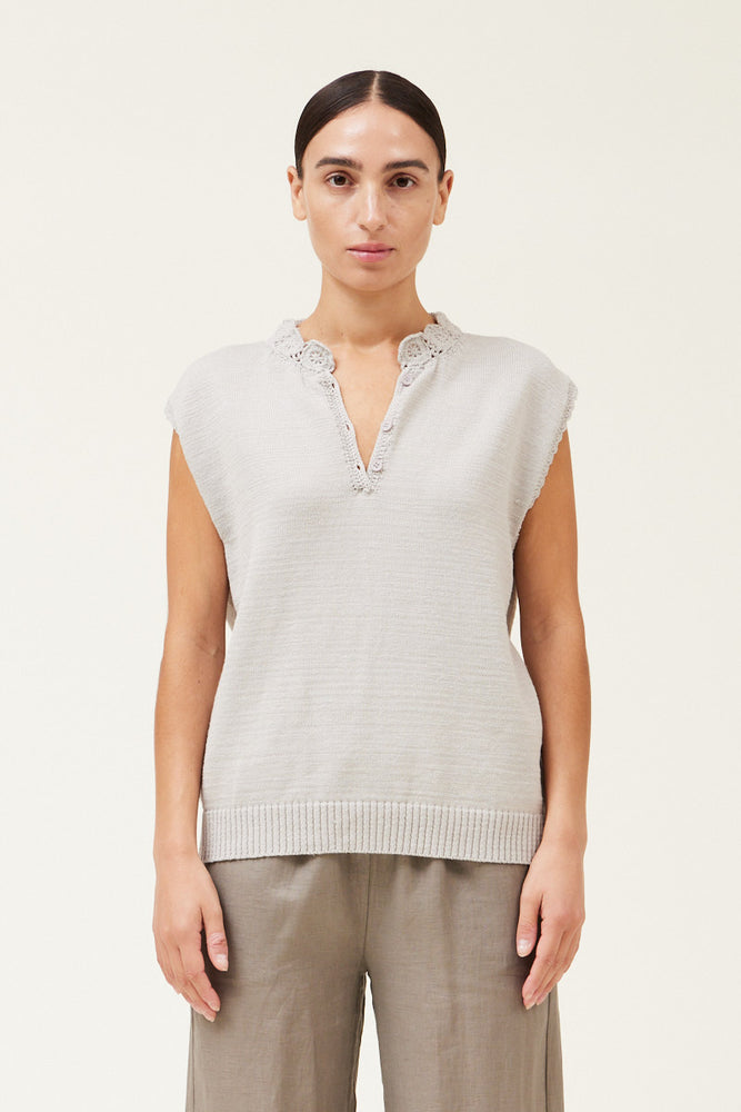 
                      
                        Front view of a woman wearing a sleeveless crochet trim sweater top 
                      
                    