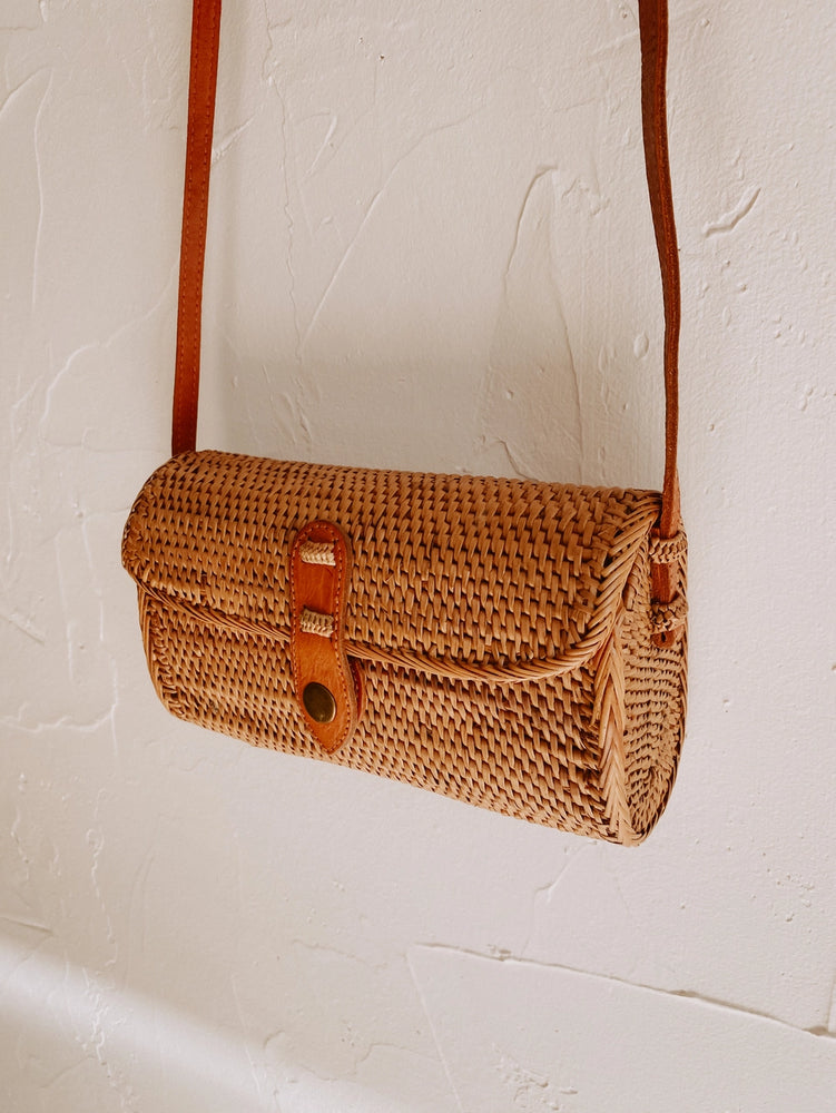 
                      
                        The Ulan Rattan Purse by Village Thrive hanging up
                      
                    