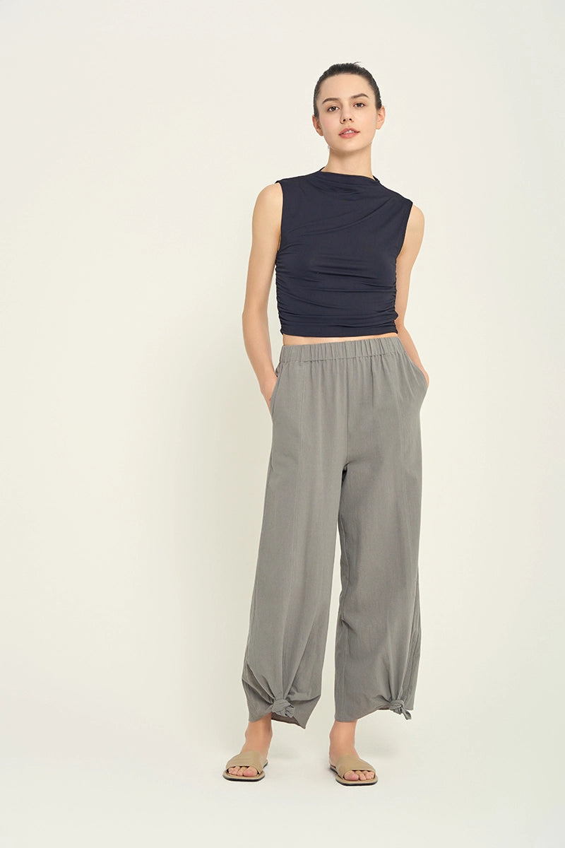 Front view of woman wearing grey knotted hem pants