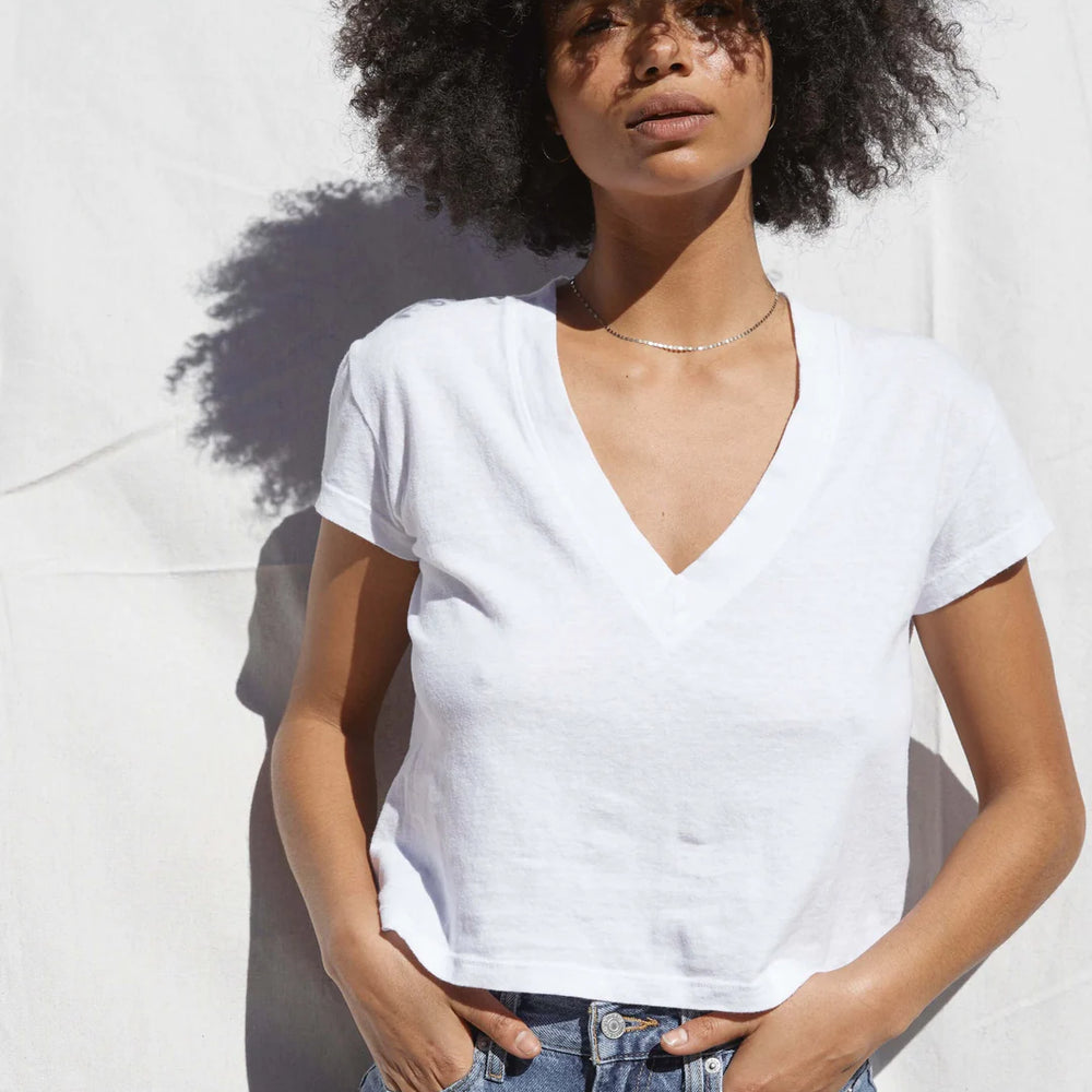 
                      
                        A woman wearing the White Alanis V-Neck Tee by the brand Perfect White Tee
                      
                    