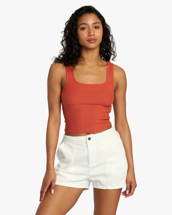 Front view of woman wearing a stretchy rib knit cropped tank top with a square neckline