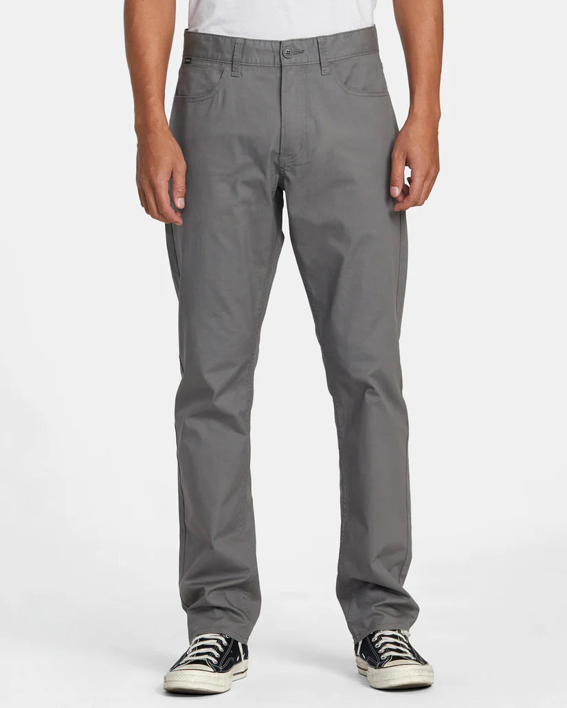 Front view of a man wearing the men's grey 5-pocket Weekend Tech Pants by RVCA