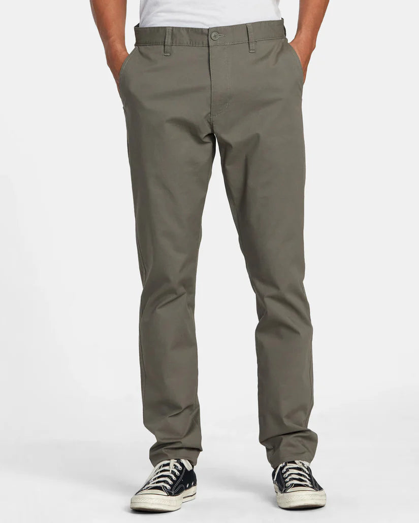 Front view of a man wearing the Olive Green Daggers Technical Chinos by RVCA