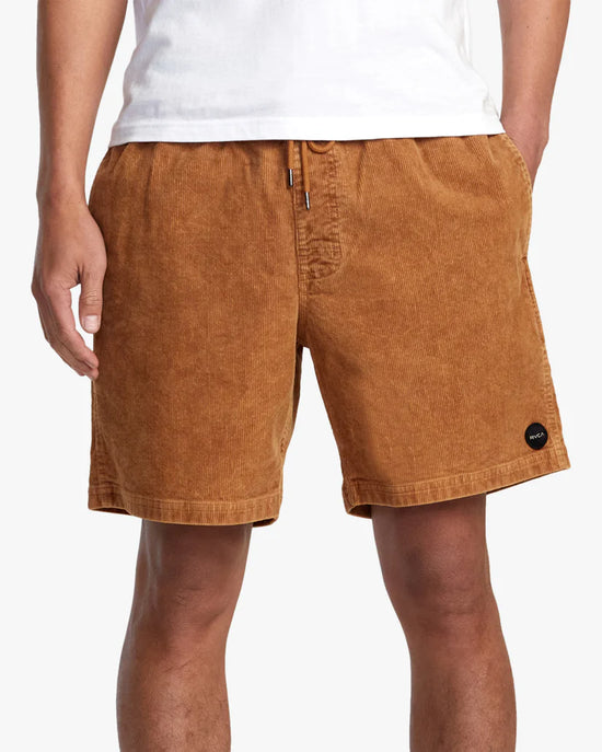 Front view of man wearing 17" elastic waist brown corduroy men's shorts by RVCA