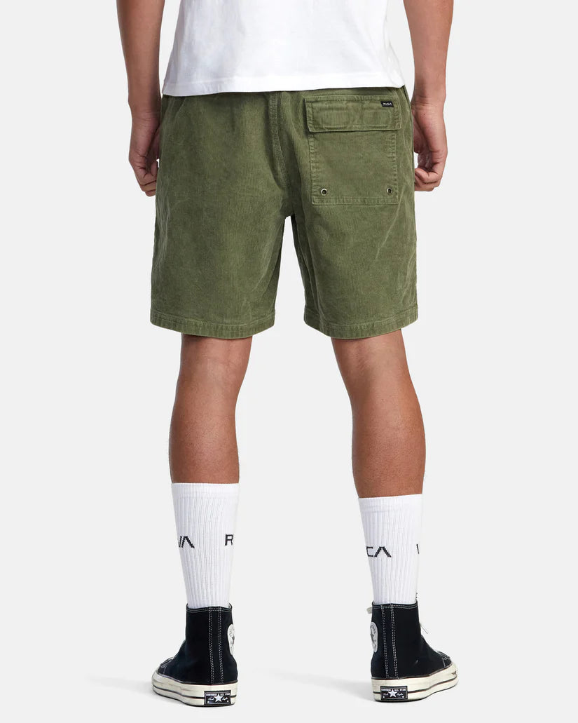 back view of man wearing 17" green corduroy shorts with an elastic waistband by RVCA