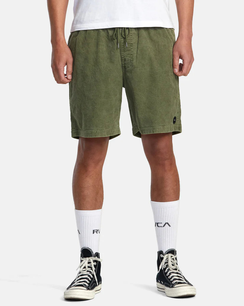 Front view of man wearing 17" green corduroy shorts with an elastic waistband by RVCA