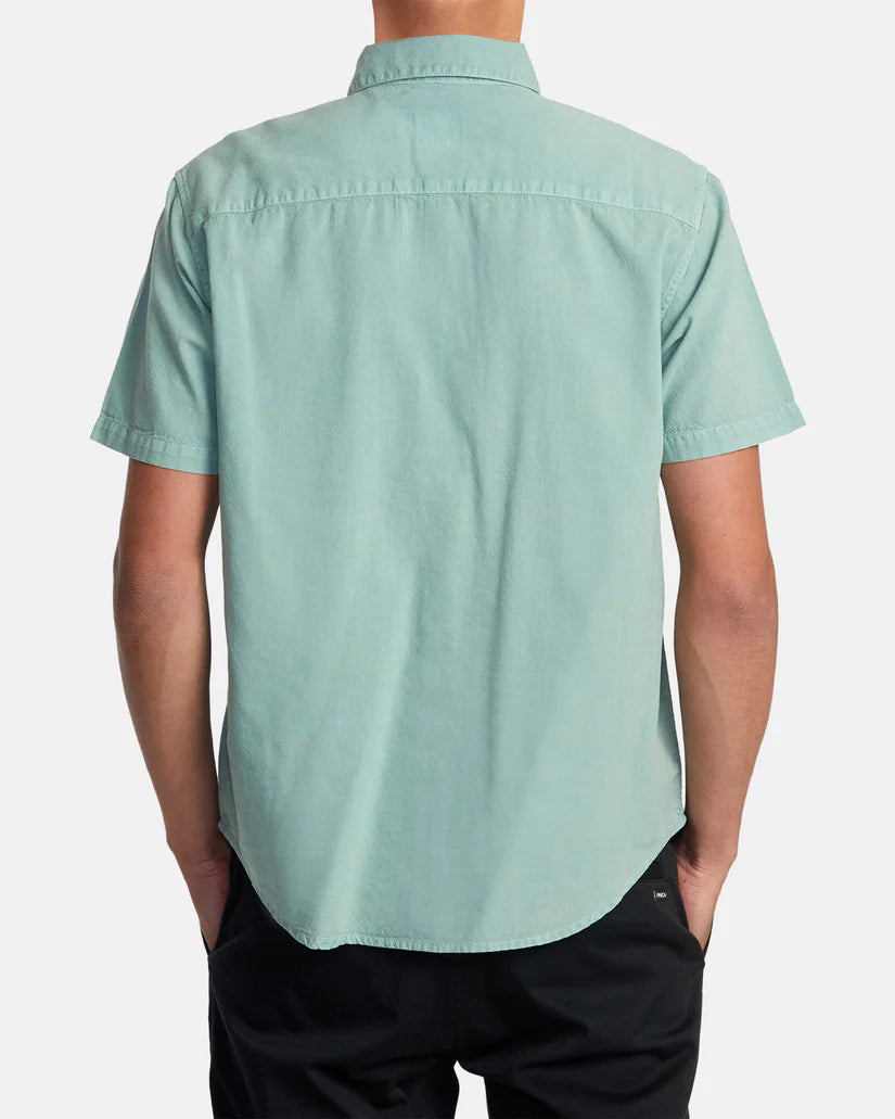Back view of man wearing a green color short sleeve button up shirt by RVCA