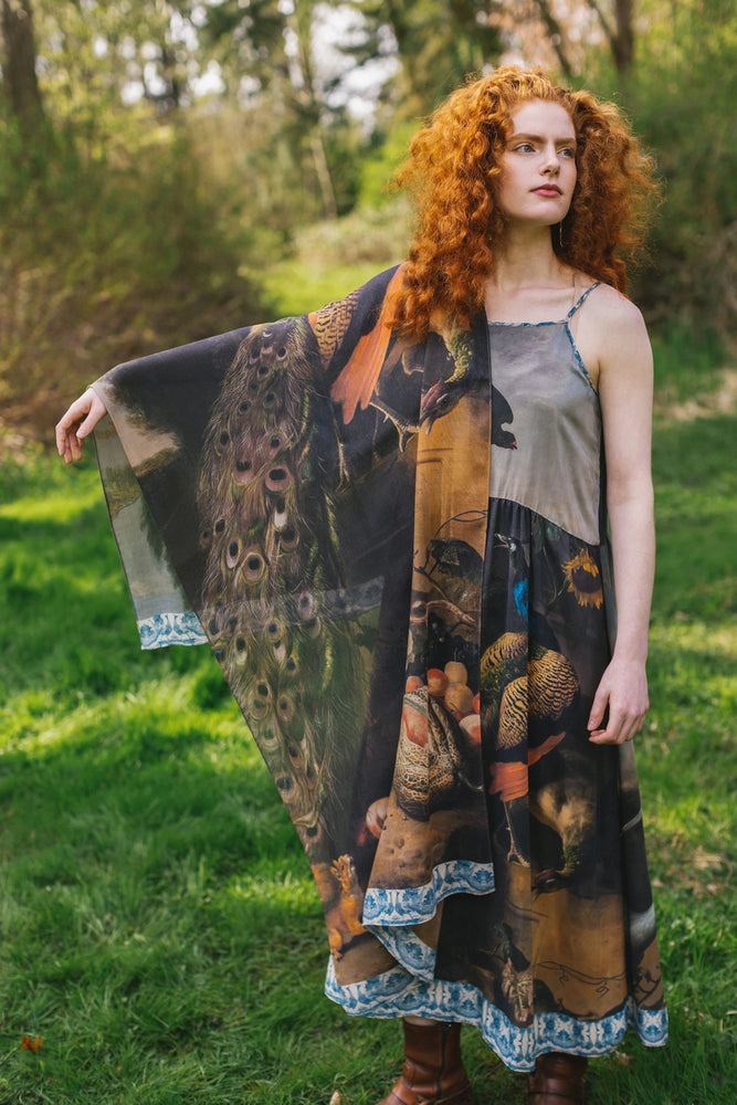 
                      
                        A woman holding out the Wild Beauty Bohemian Bamboo Scarf with Peacock Print by Market of Stars
                      
                    