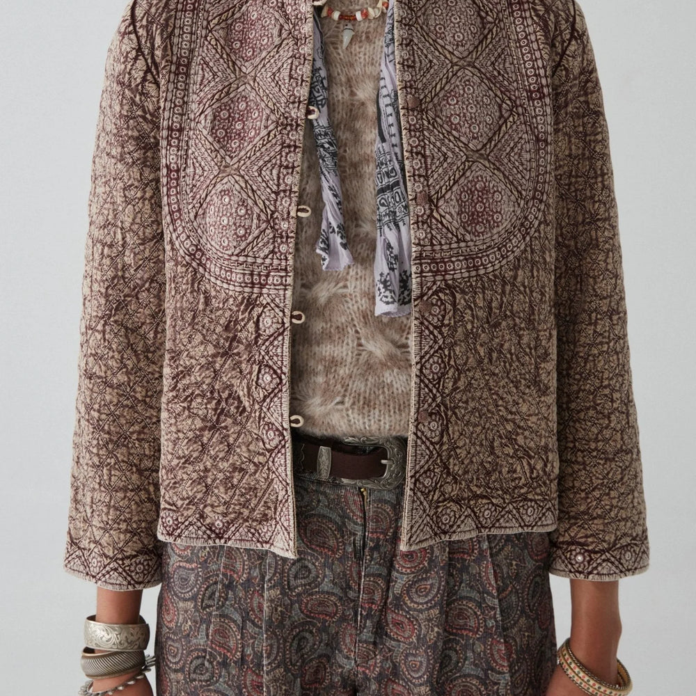 
                      
                        A woman wearing the Camilla Jacket by Maison Hotel unopened in the front, layered over another top and styled with a scarf and paisley pants
                      
                    