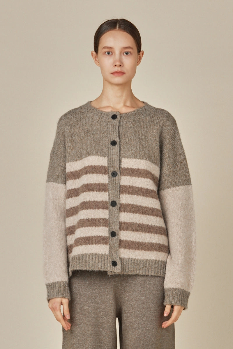 Front view of a woman wearing a grey, brown and beige colorblock striped cardigan