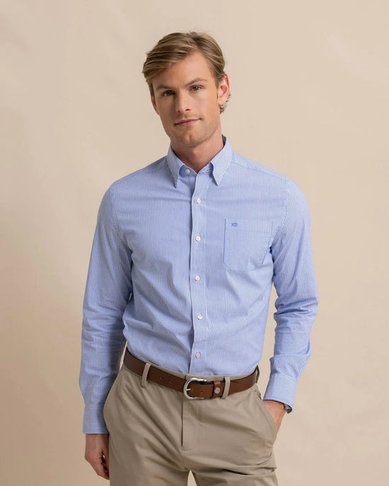 Front view of man wearing a blue and white pinstriped long sleeve button up shirt by Southern Tide