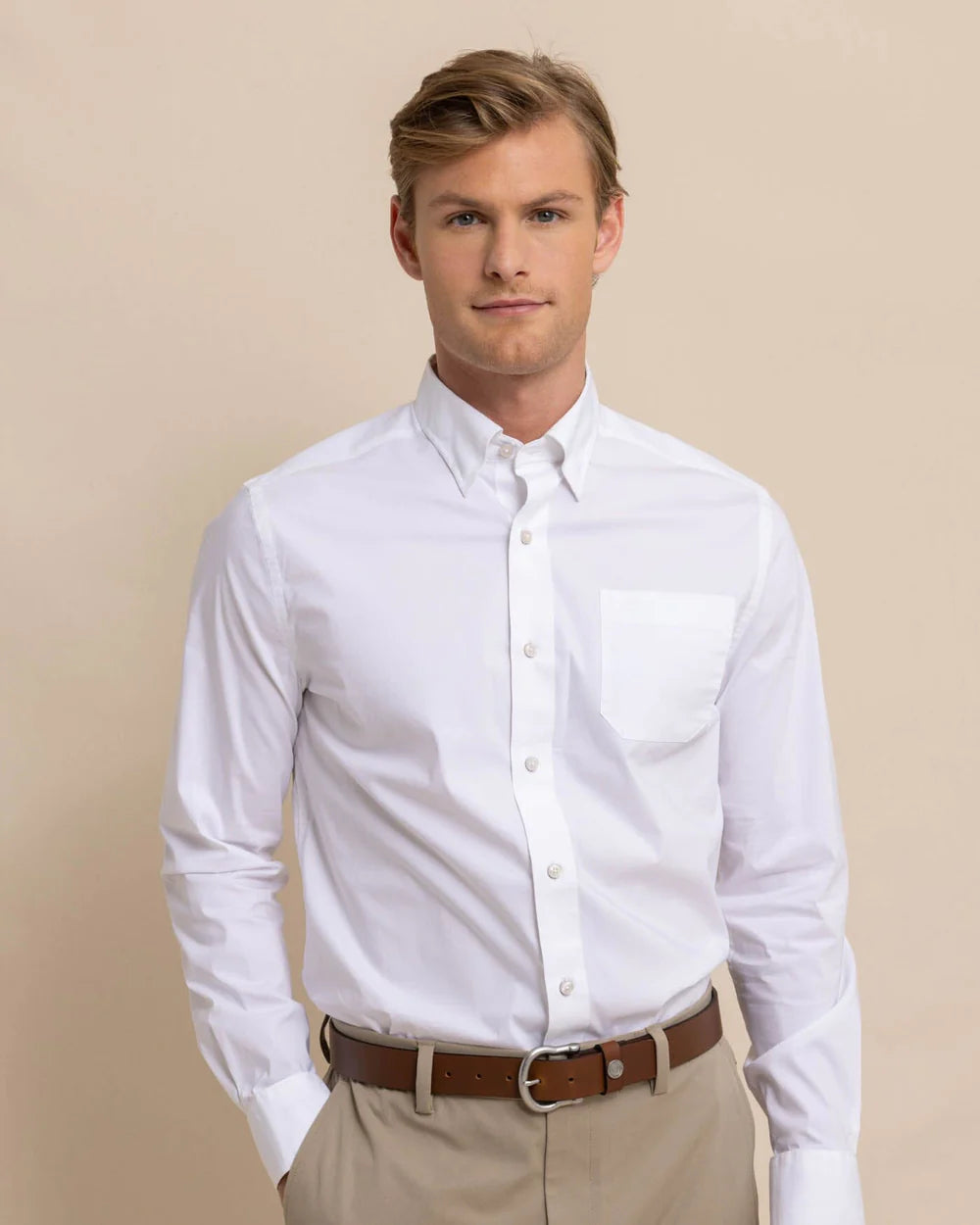 Front view of man wearing a solid white long sleeve button up shirt from Southern Tide. 