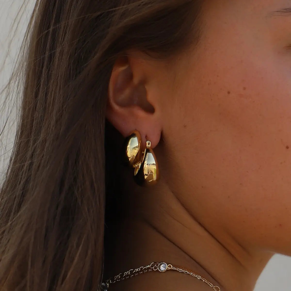 Woman wearing the gold Coco Chunky Hoop Earrings from Katie Waltman Jewelry