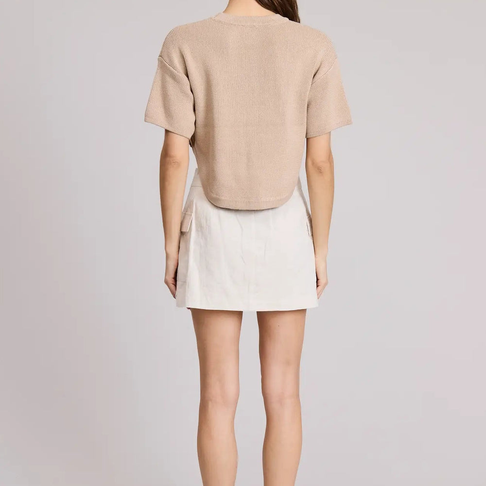 
                      
                        Woman wearing a beige top and white skirt
                      
                    