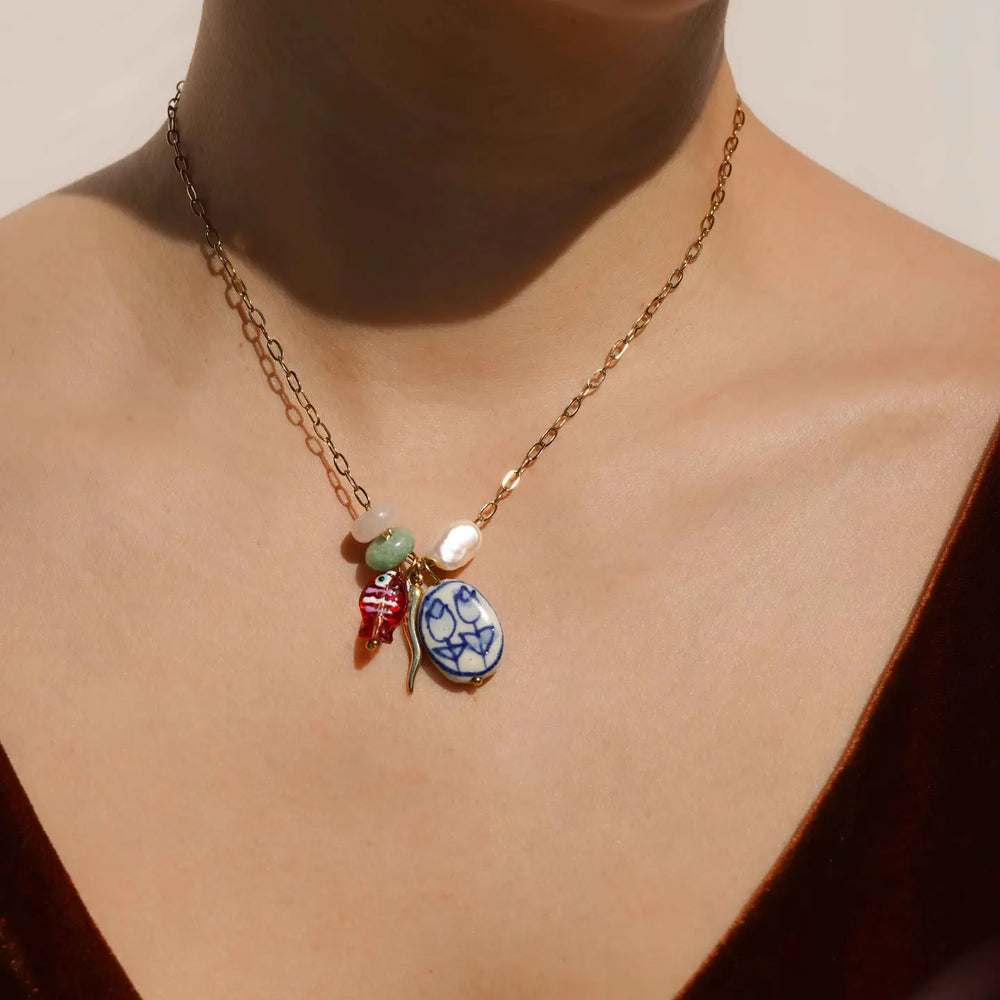 A person wearing the KOZAKH Emerson Necklace with colorful charms