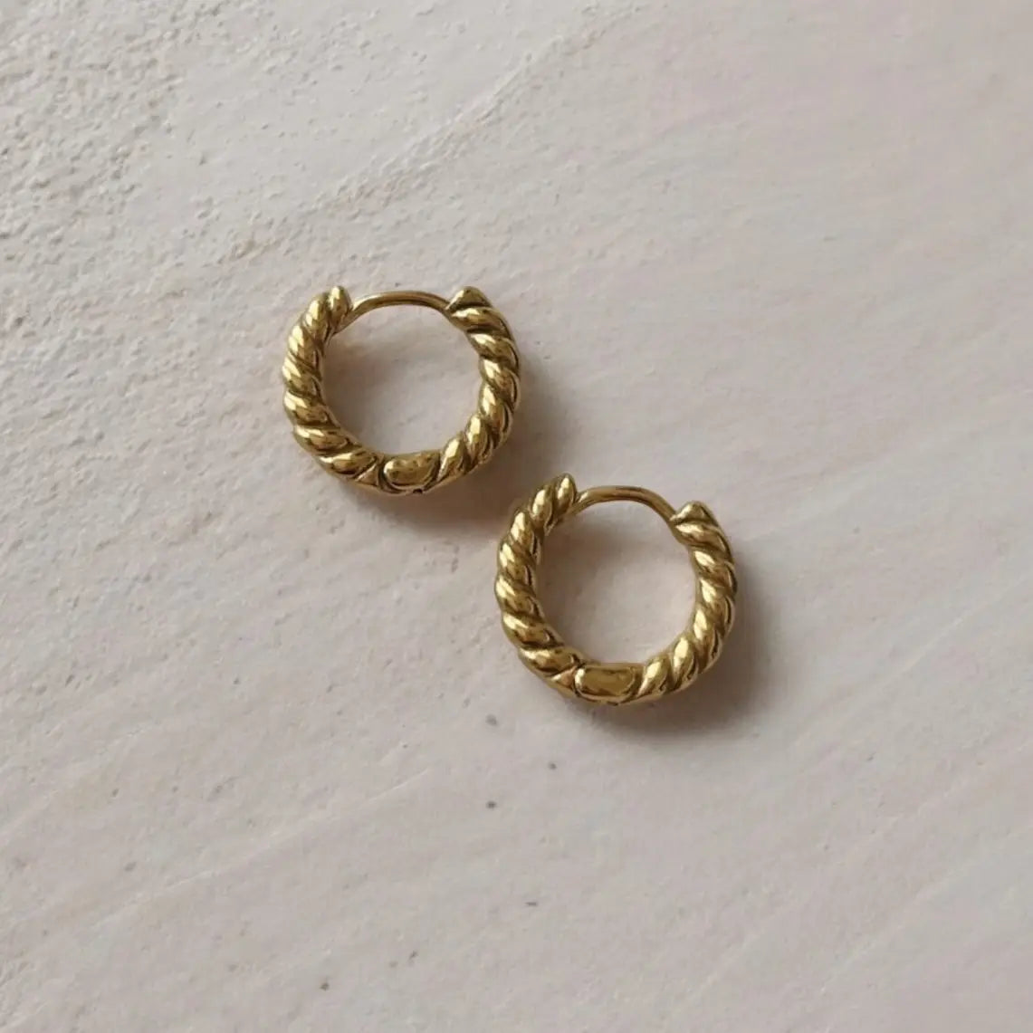 Snug gold hoops with a twisted design