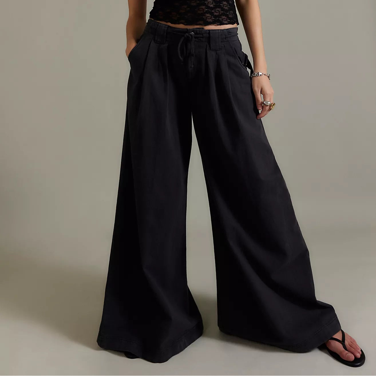 Woman wearing a black sleeveless top and wide-leg pants from Free People