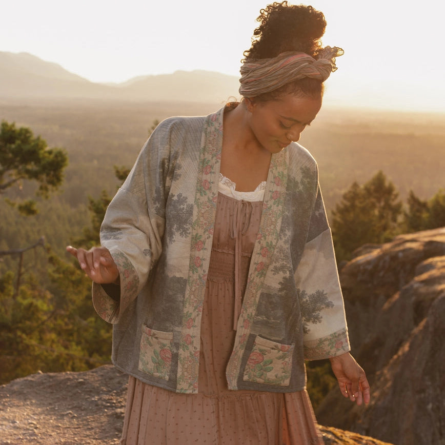 A woman standing outside wearing the Still I Rise Fleece Cottage Cardigan Kimono Jacket by Market Of Stars