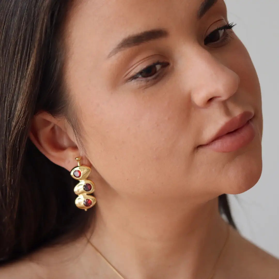 A woman wearing the Liv Bella Vita Velvet Martini Olive Earrings
