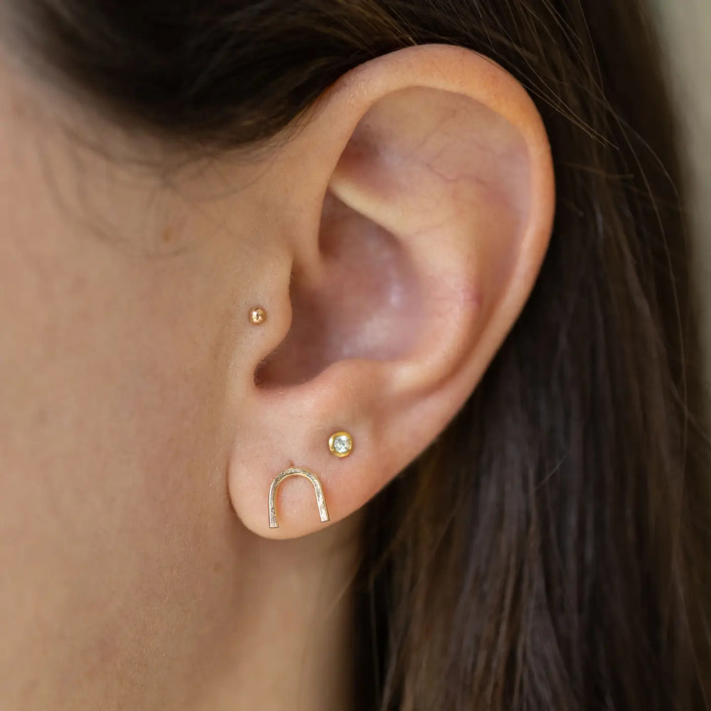 Woman wearing the 14KT Gold Filled Arch Stud Earrings by The Land Of Salt