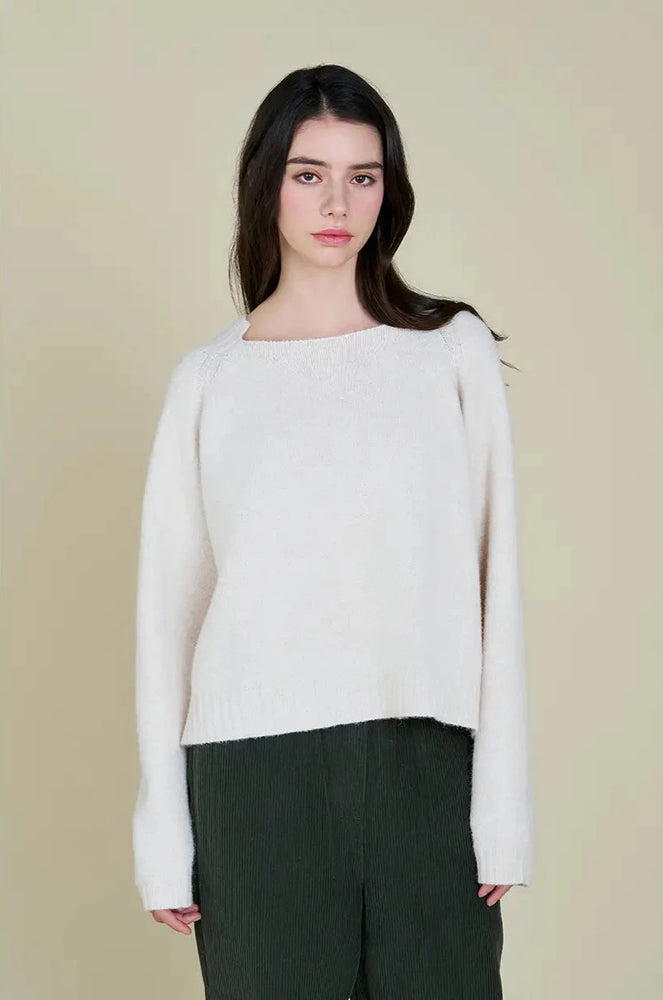 This pullover sweater features a unique neckline detail that squares off at the front