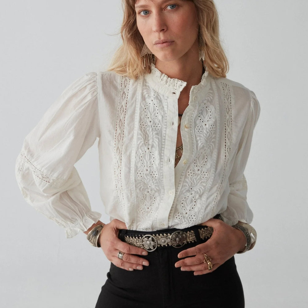 
                      
                        A woman wearing the Emmanuelle Blouse by Maison Hotel tucked into black jeans
                      
                    