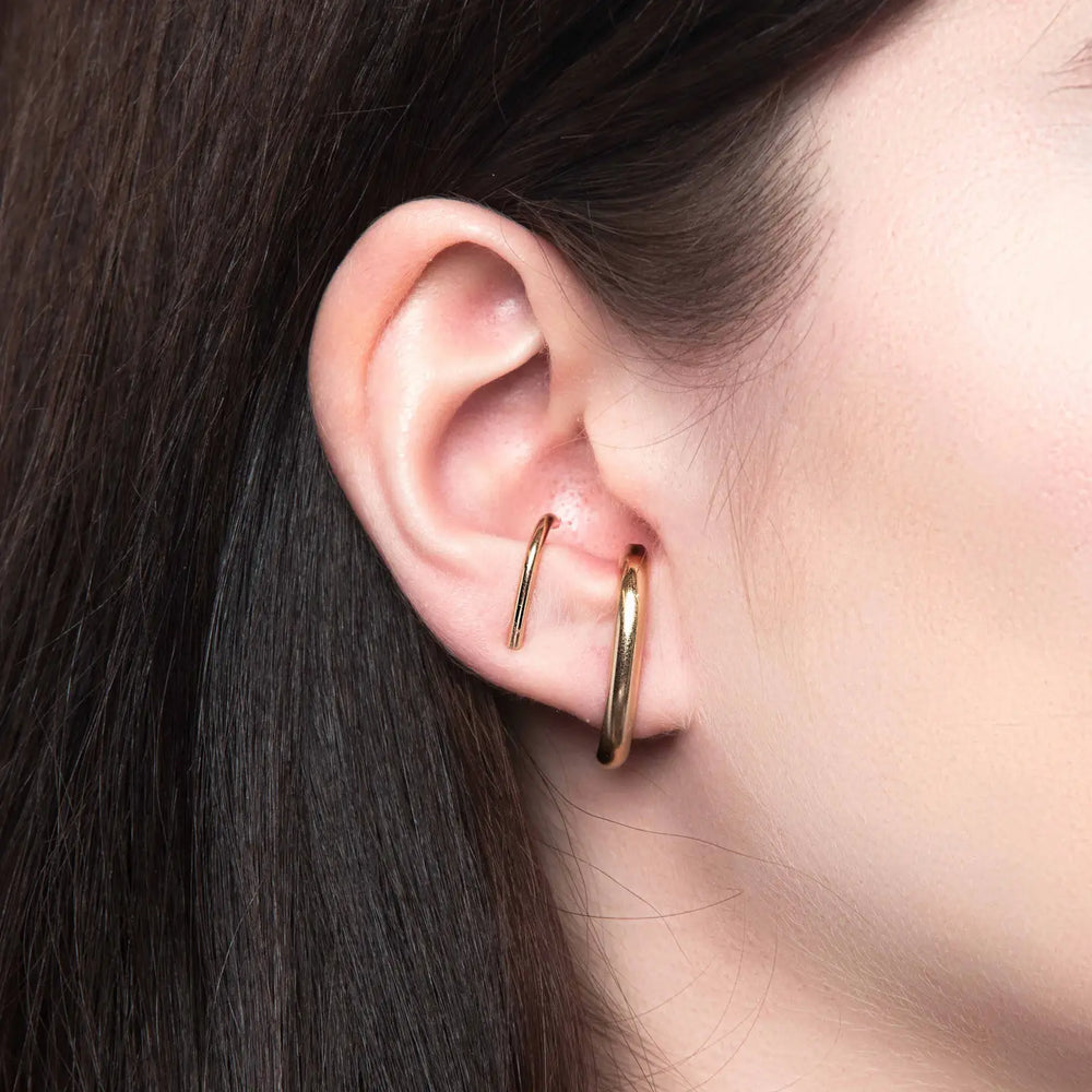 
                      
                        Person wearing the Gold Wide Suspension Hoop Earrings by Glamrocks Jewelry
                      
                    