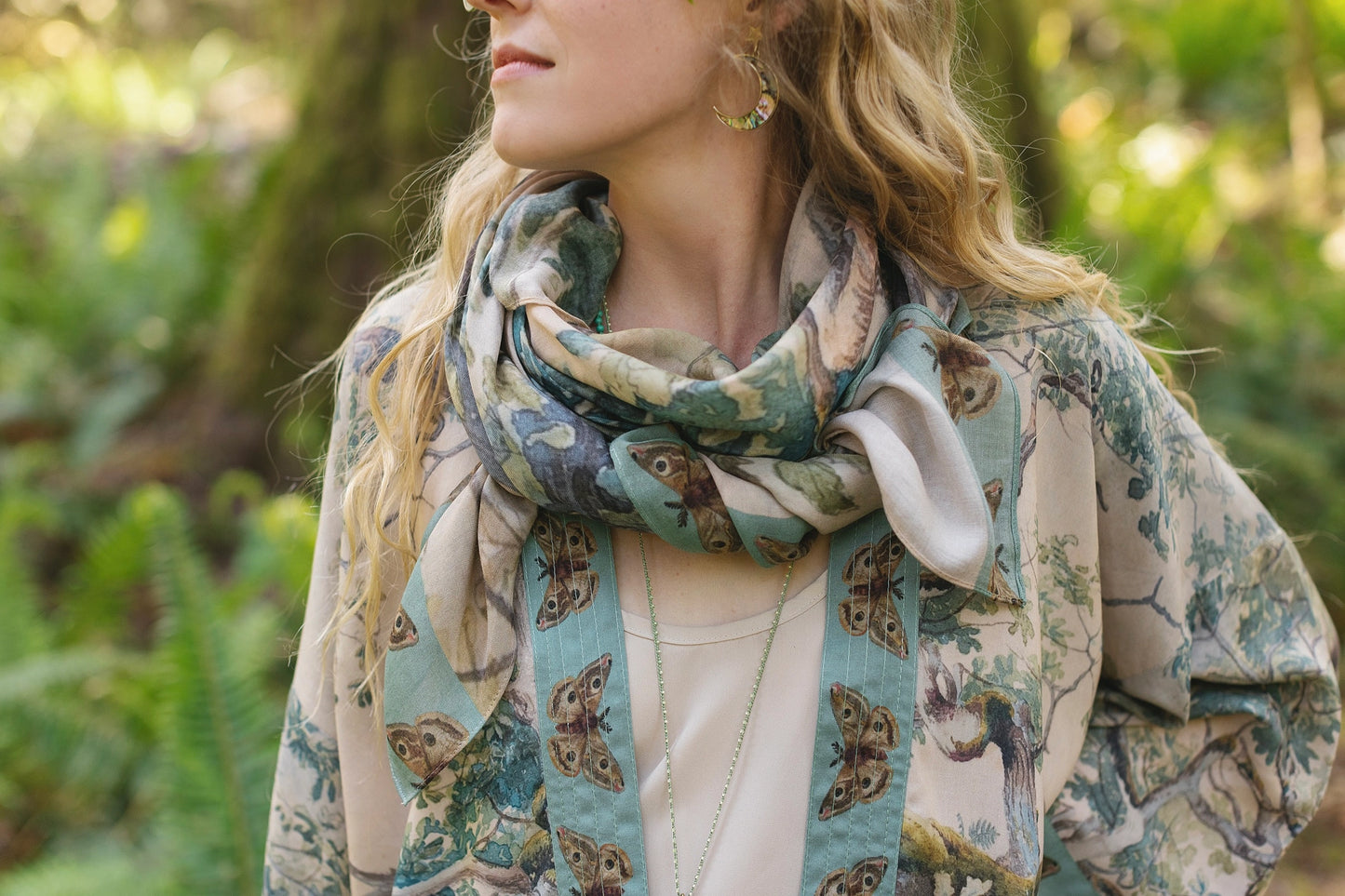 A woman with the Earth and Sky Bohemian Bamboo Scarf with Tree Print by Market of Stars wrapped around her neck like a scarf