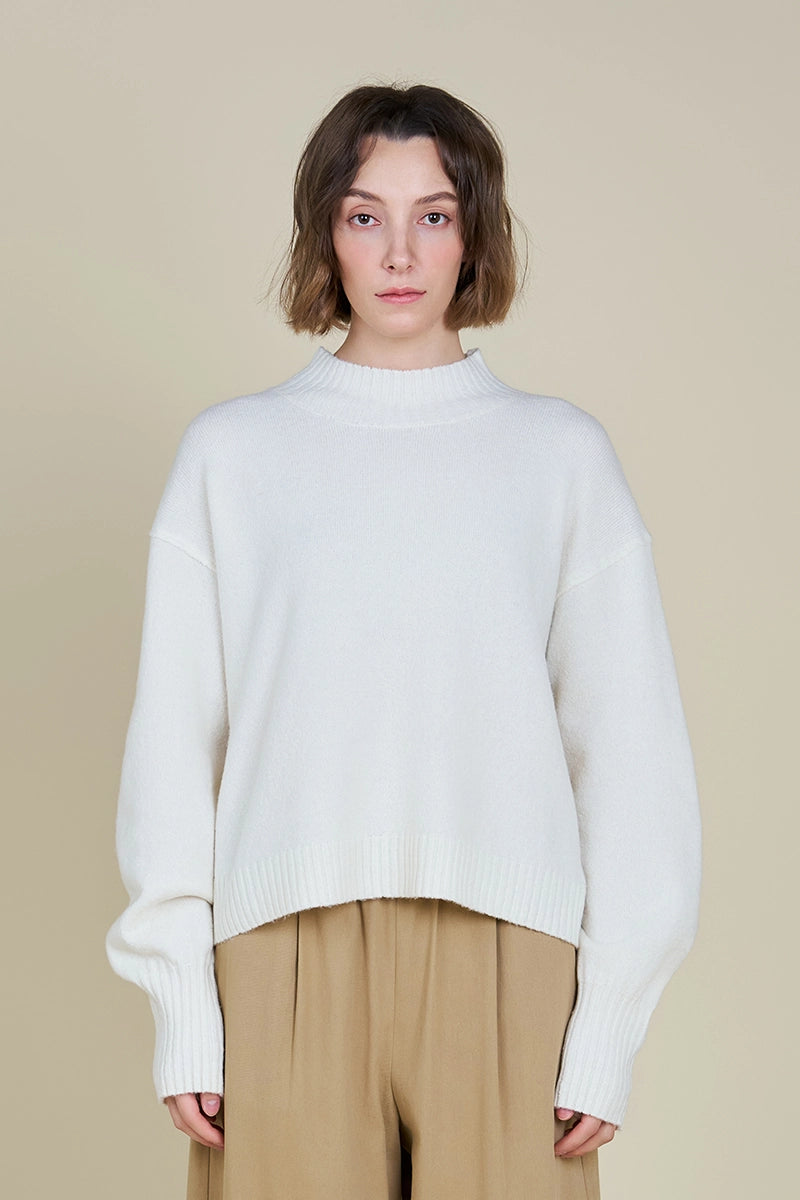 A woman wearing a classic pullover sweater with ribbed trims and a wide turtleneck