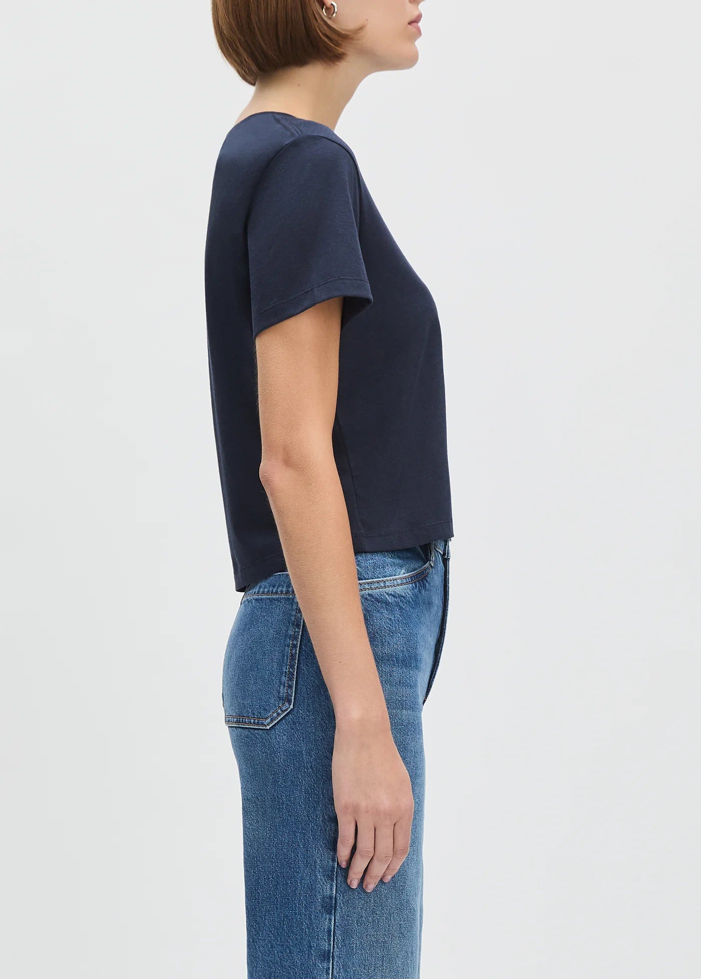 Person wearing a cropped navy blue t-shirt