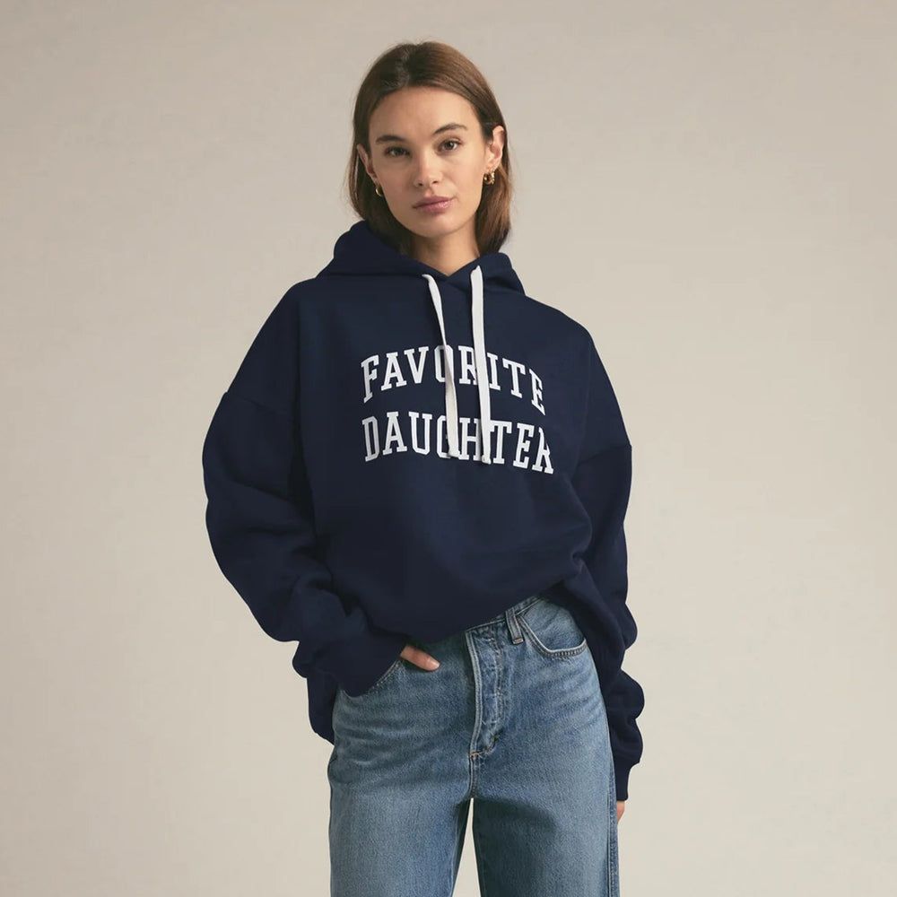 Person wearing a navy hoodie from the brand Favorite Daughter.