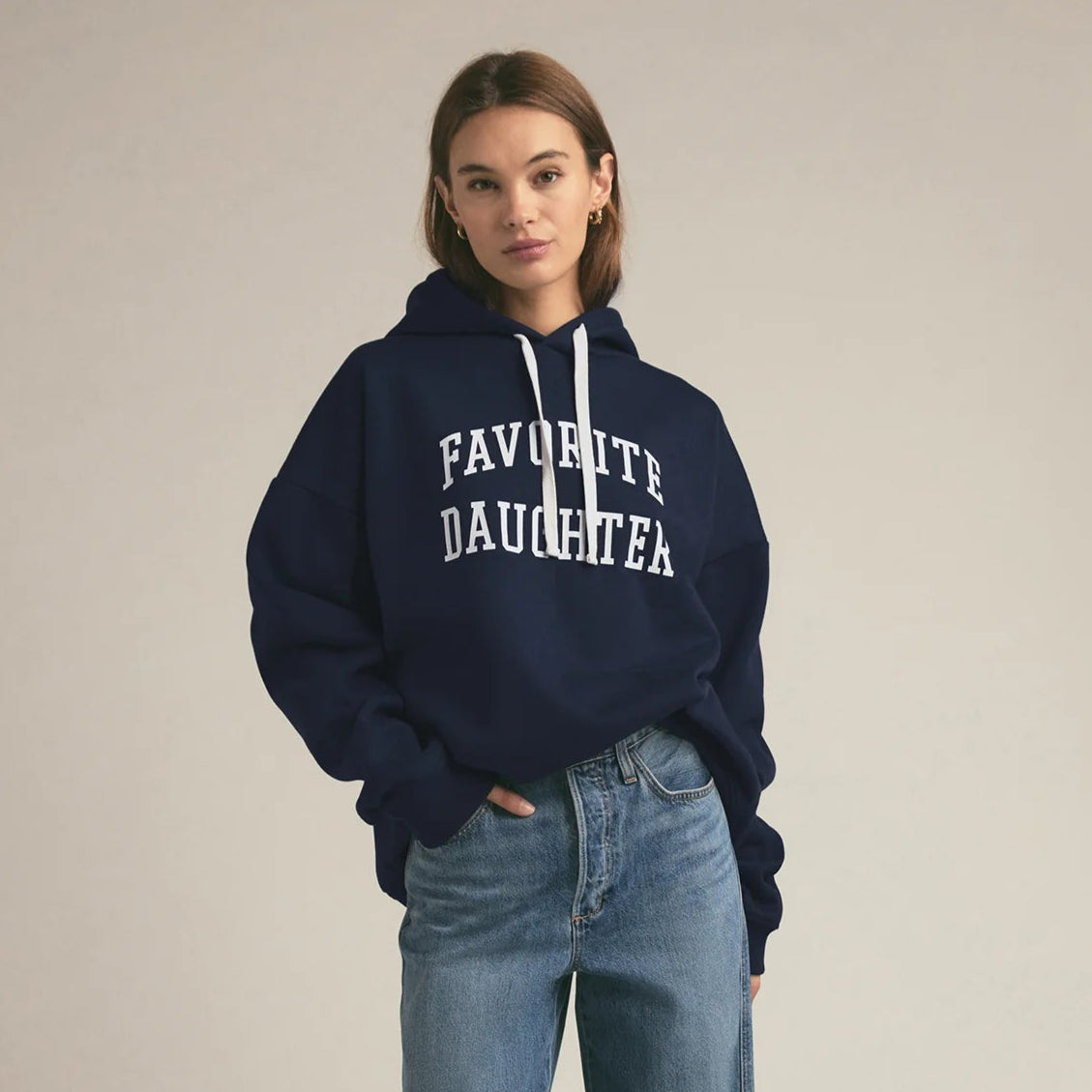 Person wearing a navy hoodie from the brand Favorite Daughter.