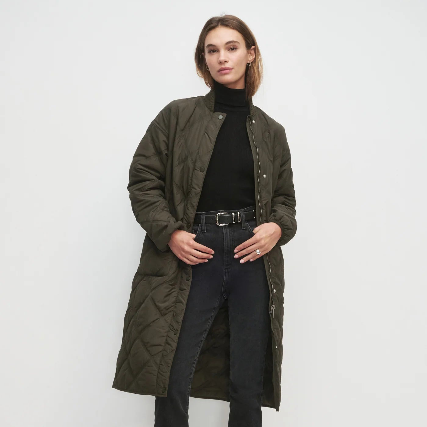 Woman wearing a long green quilted jacket from Favorite Daughter