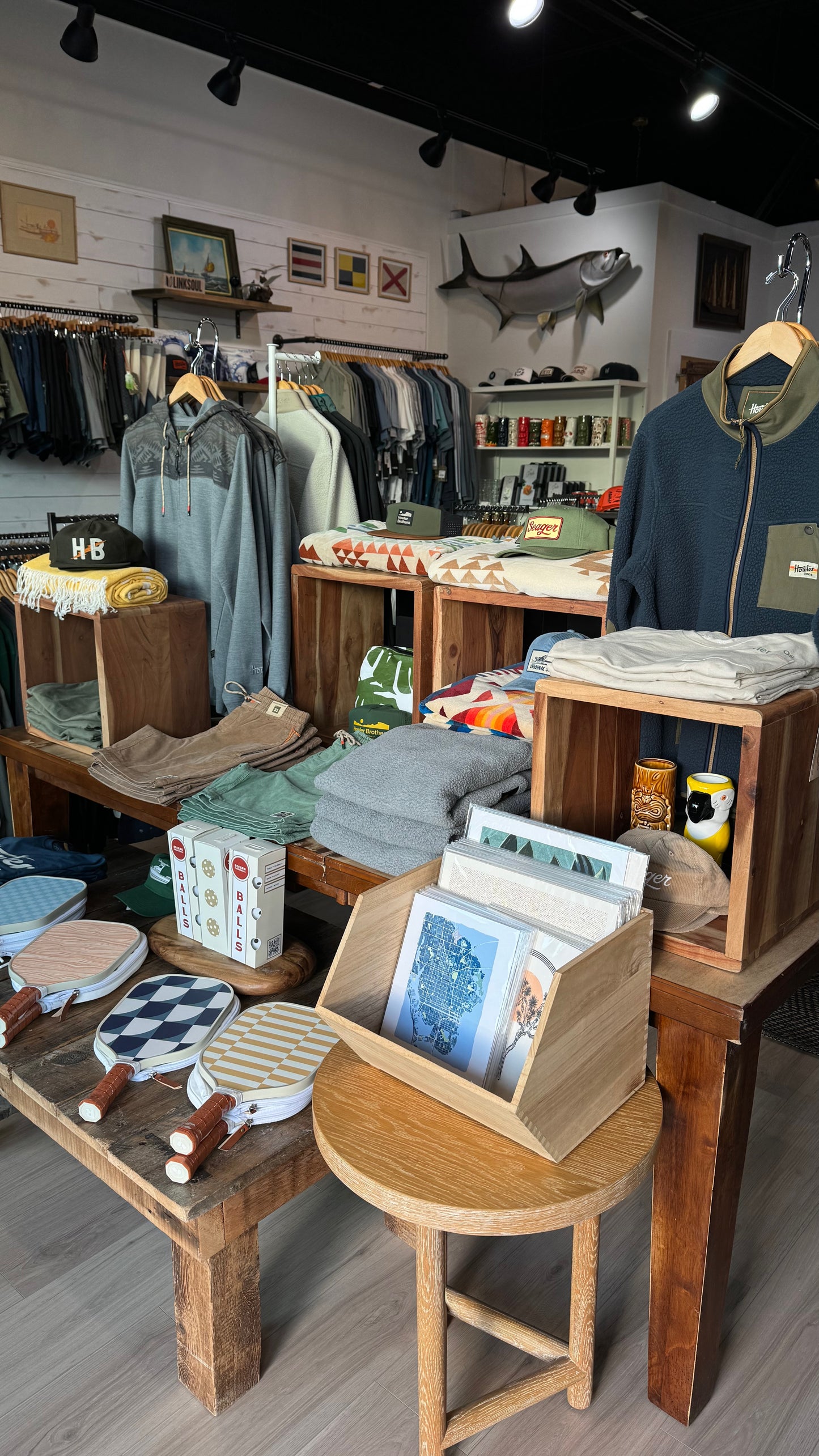 Store interior with clothing racks, tables, and shelves displaying various items.