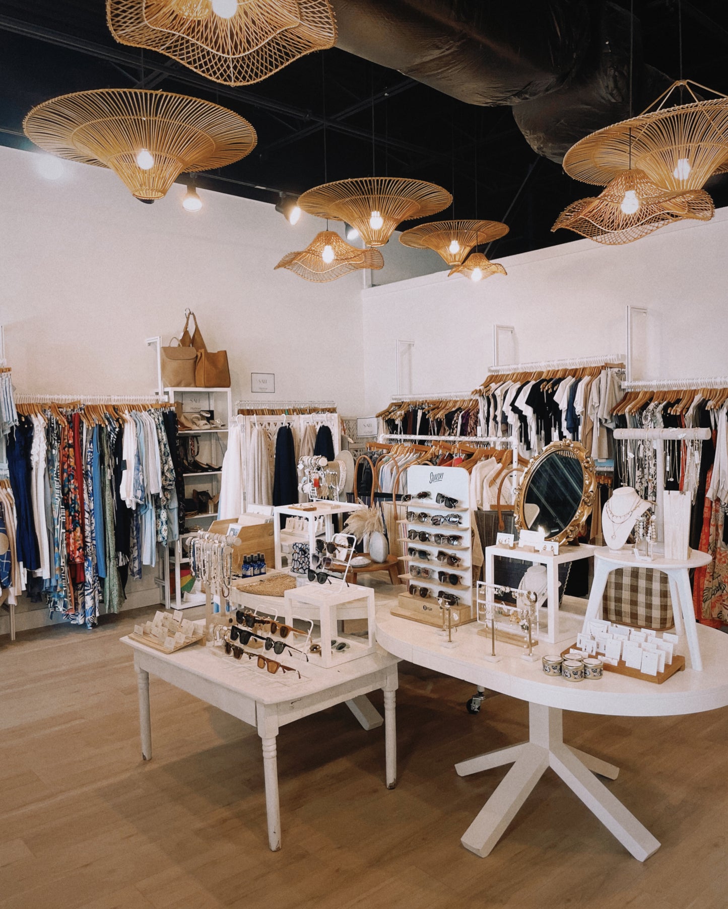 Interior of a store with clothing racks, tables, and decorative items.