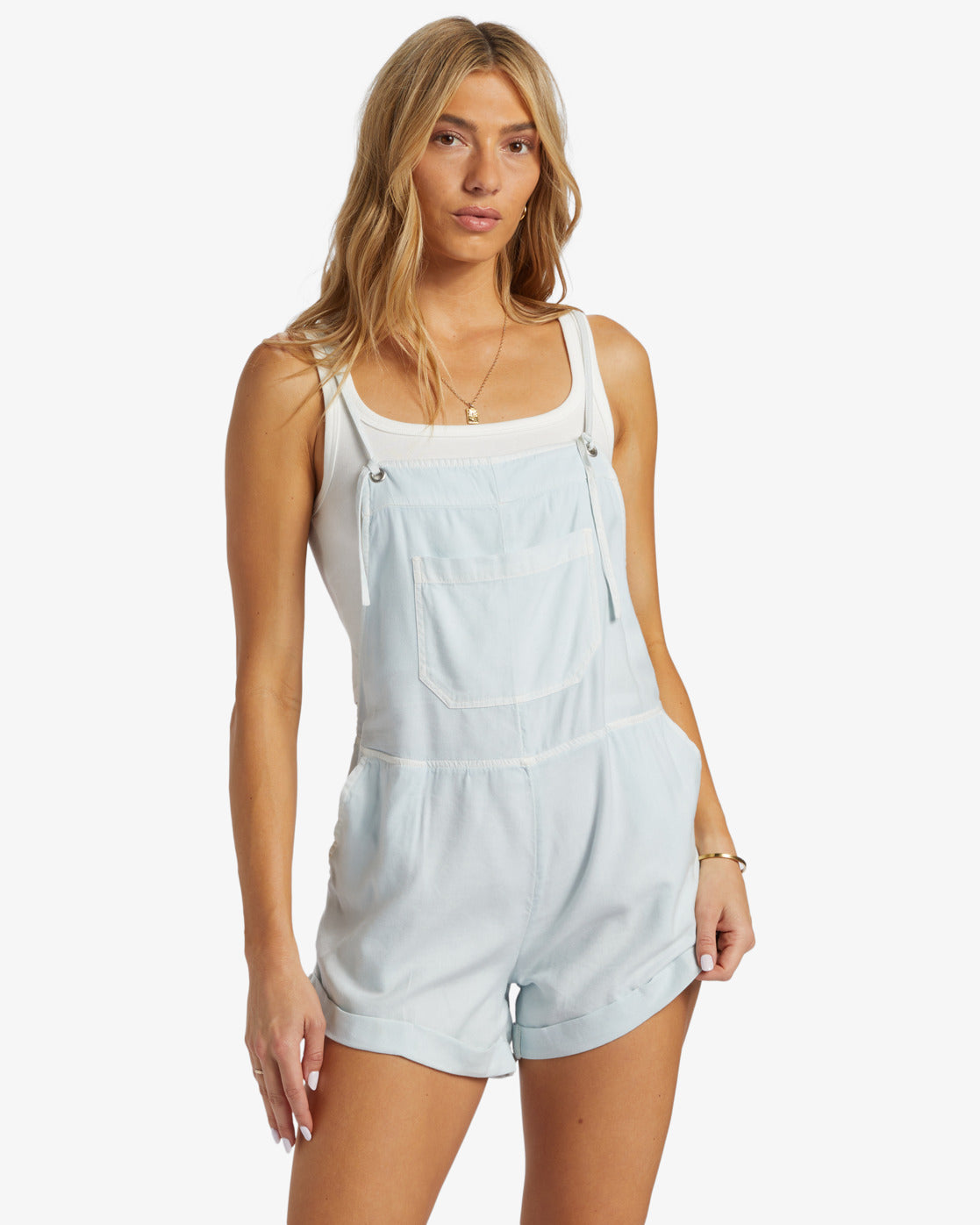 Front view of woman wearing a light blue color shorts romper by Billabong