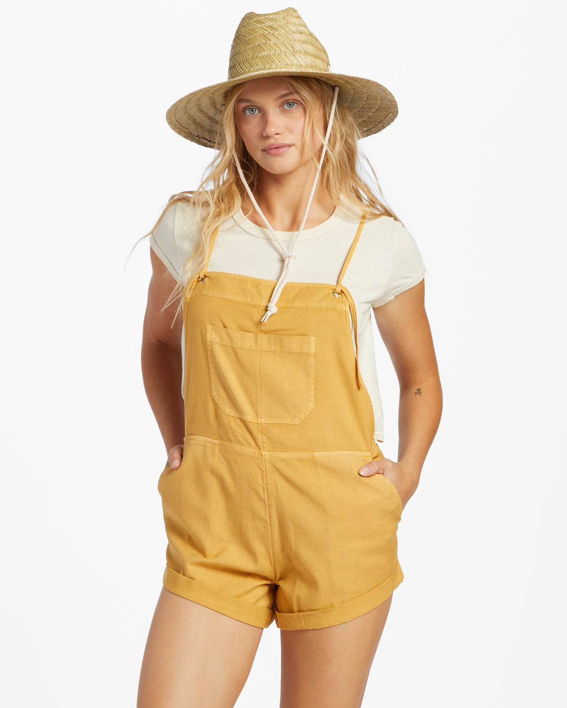 Front view view of model wearing a honey yellow color shorts romper by Billabong