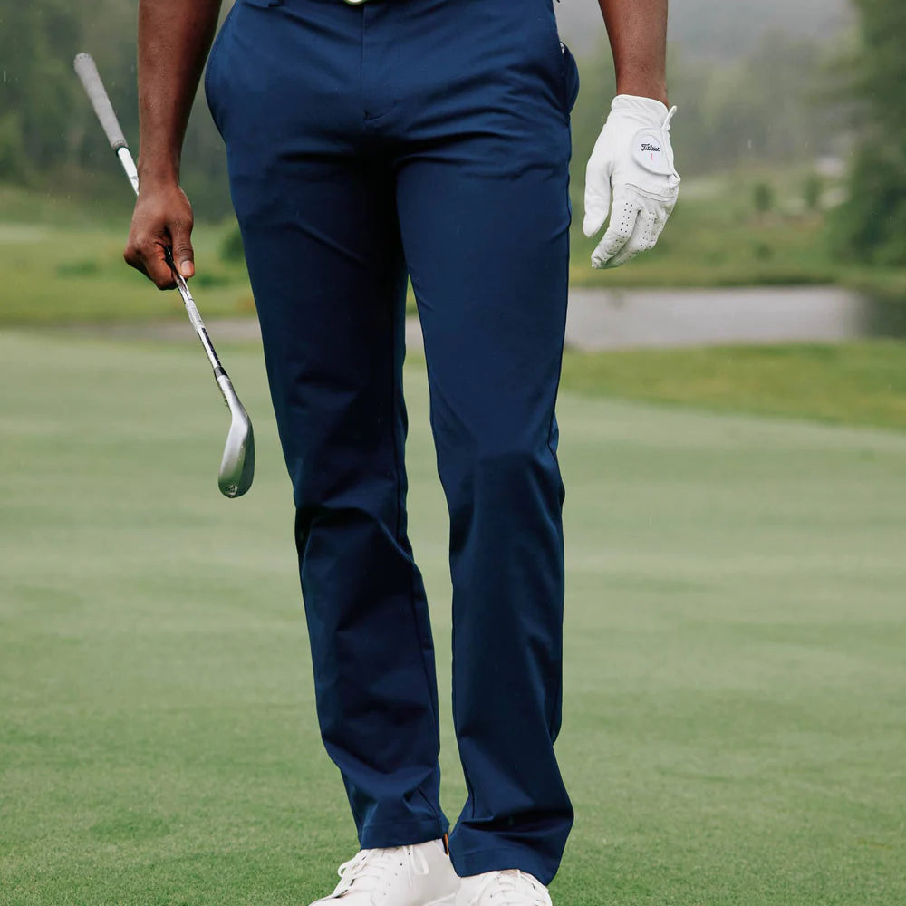 
                      
                        Man playing golf in the blue performance pants by Southern Tide
                      
                    