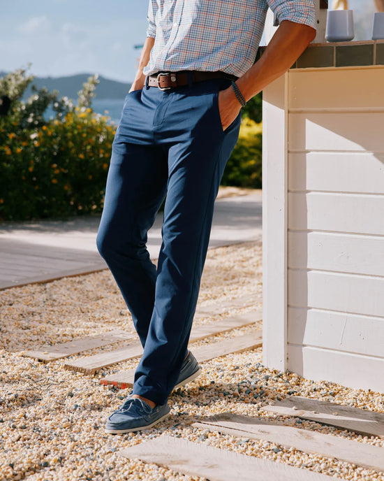 Side view of a man wearing the navy Jack Performance Pants by Southern Tide