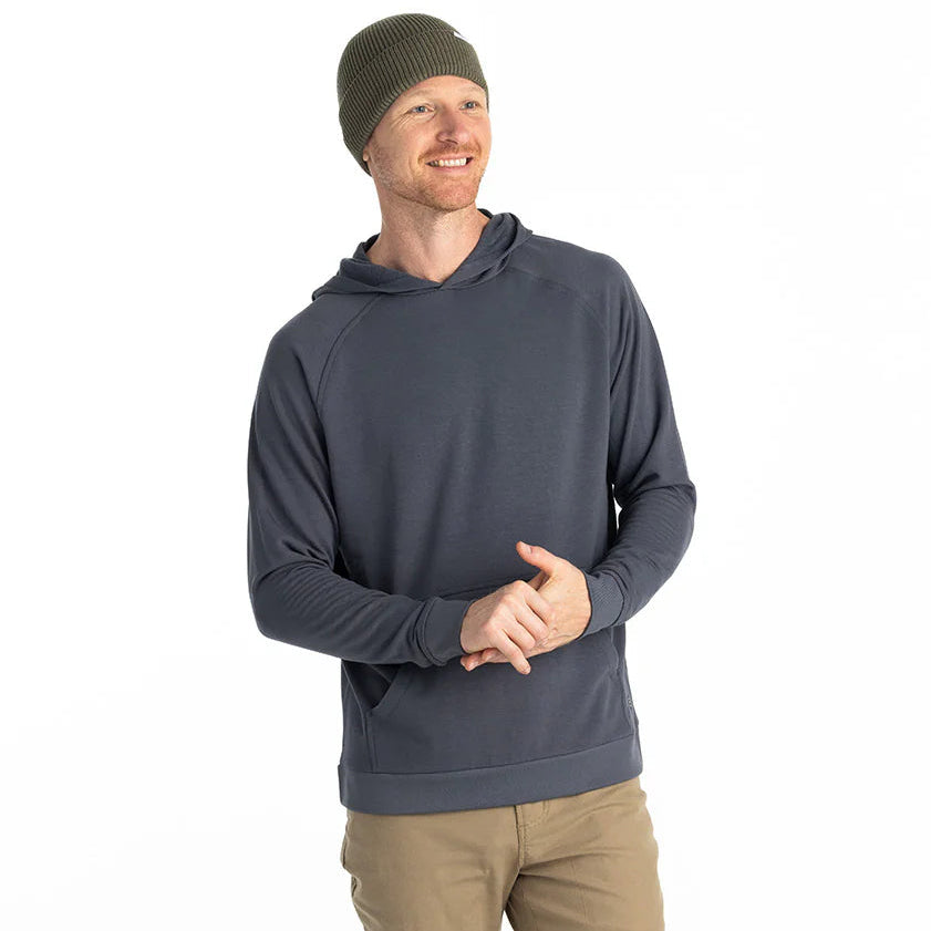 A man wearing the Men's Bamboo Lightweight Fleece Hoodie by Free Fly in the color Storm Cloud