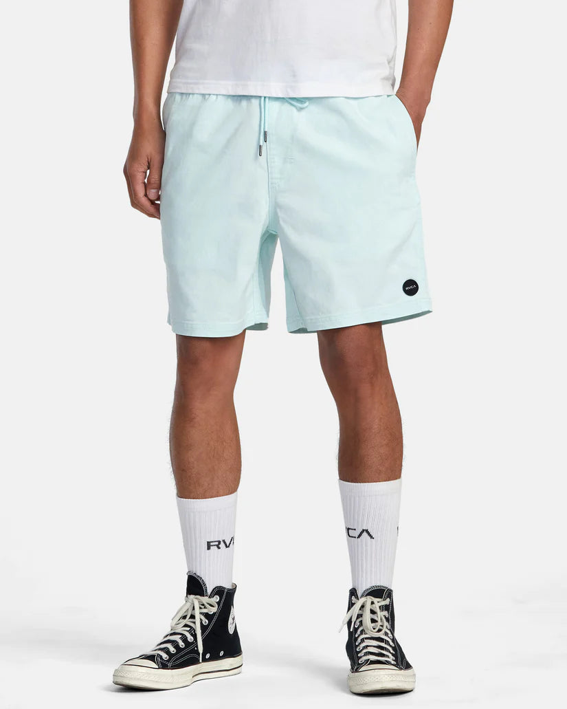 Front view of man wearing light blue 17" walk shorts by RVCA with an elastic waistband and side seam pockets