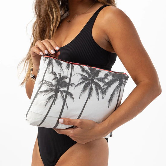 Woman holding the palm tree print Mid Kalapana pouch bag