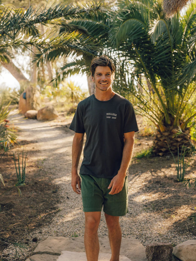 
                      
                        man wearing Mollusk's faded black Mollusk Shop Tee
                      
                    