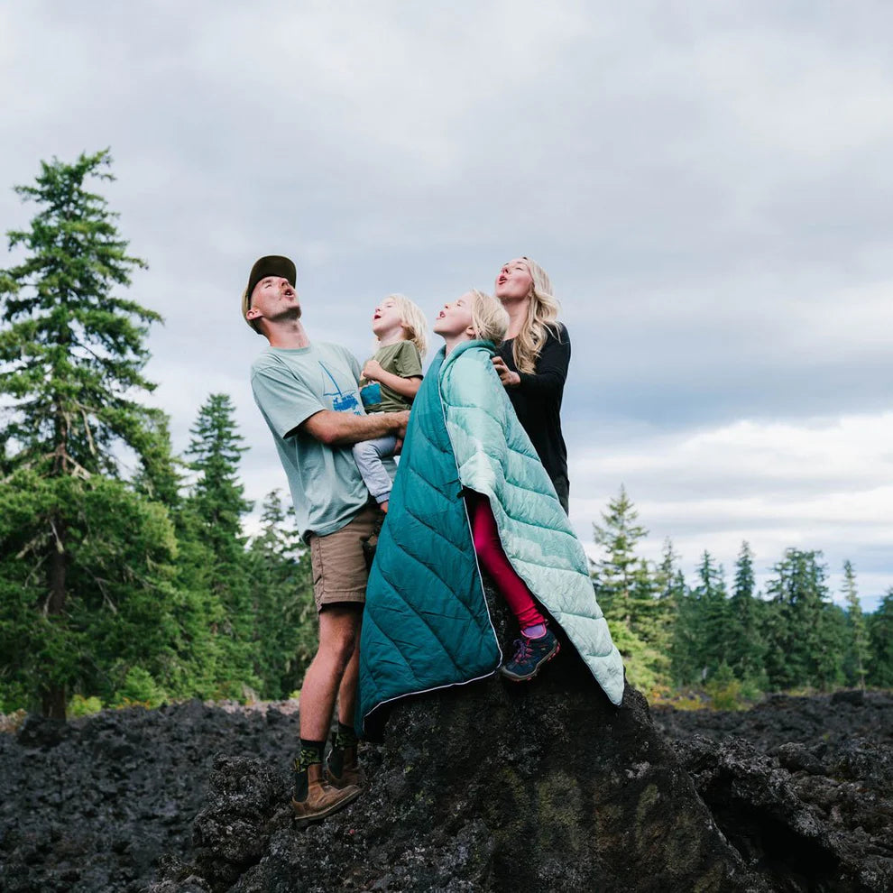 Family in nature using Rumpl's Original Puffy Blanket (1 Person) in the color Cascade Fade