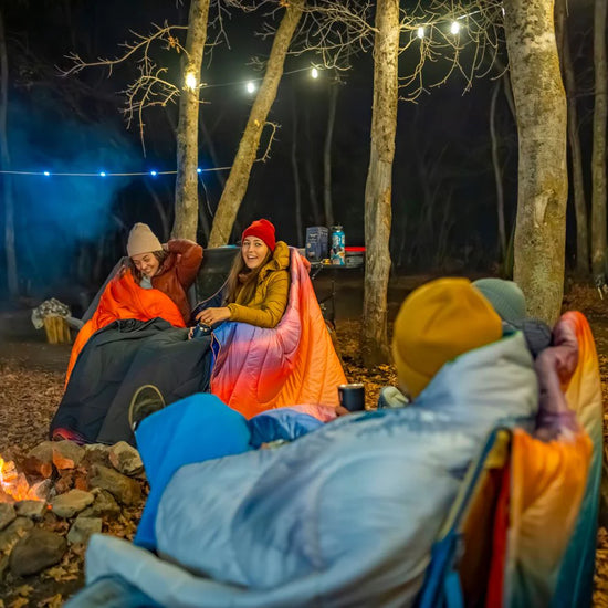 People outside with Rumpl's Original Puffy Blanket (1 Person) in the color Sierra Sunset Fade