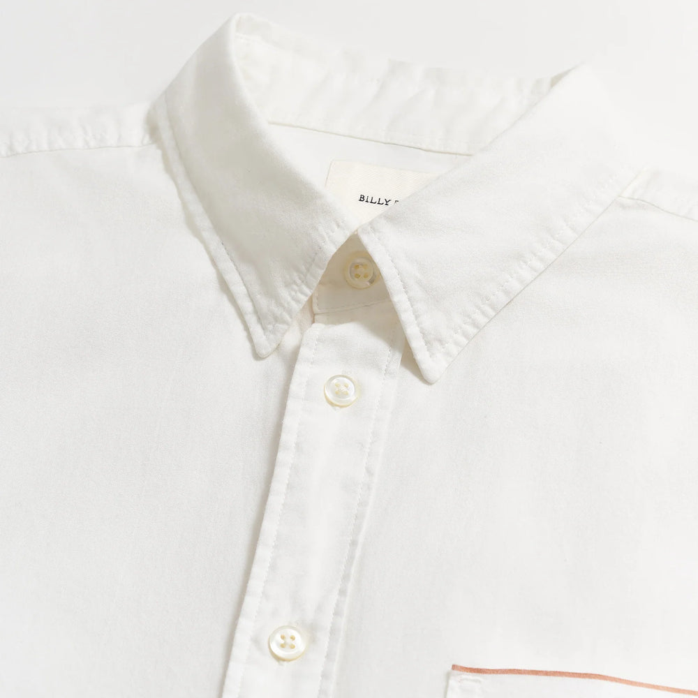 
                      
                        Close up flat lay view of the collar and buttons on a men's white button down shirt by Billy Reid
                      
                    
