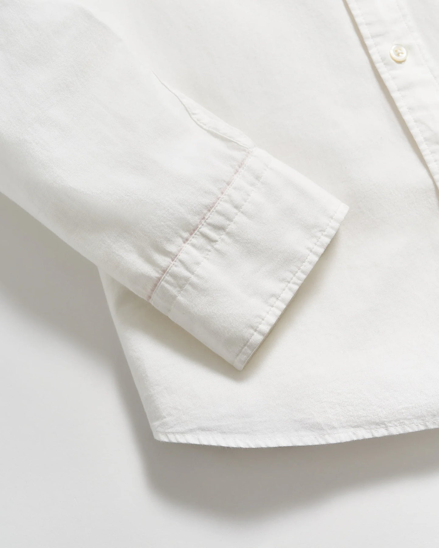 Close up view of sleeve cuffs on a men's white button down shirt by Billy Reid