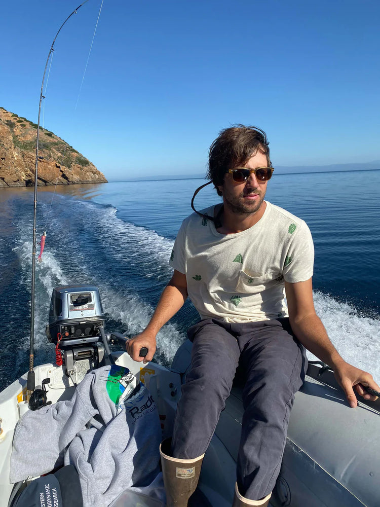 
                      
                        Man on a boat wearing Mollusk's faded navy Scout Pants
                      
                    