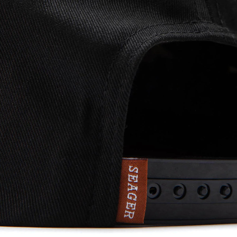
                      
                        Close-up of a black cap with a Seager brand label 
                      
                    